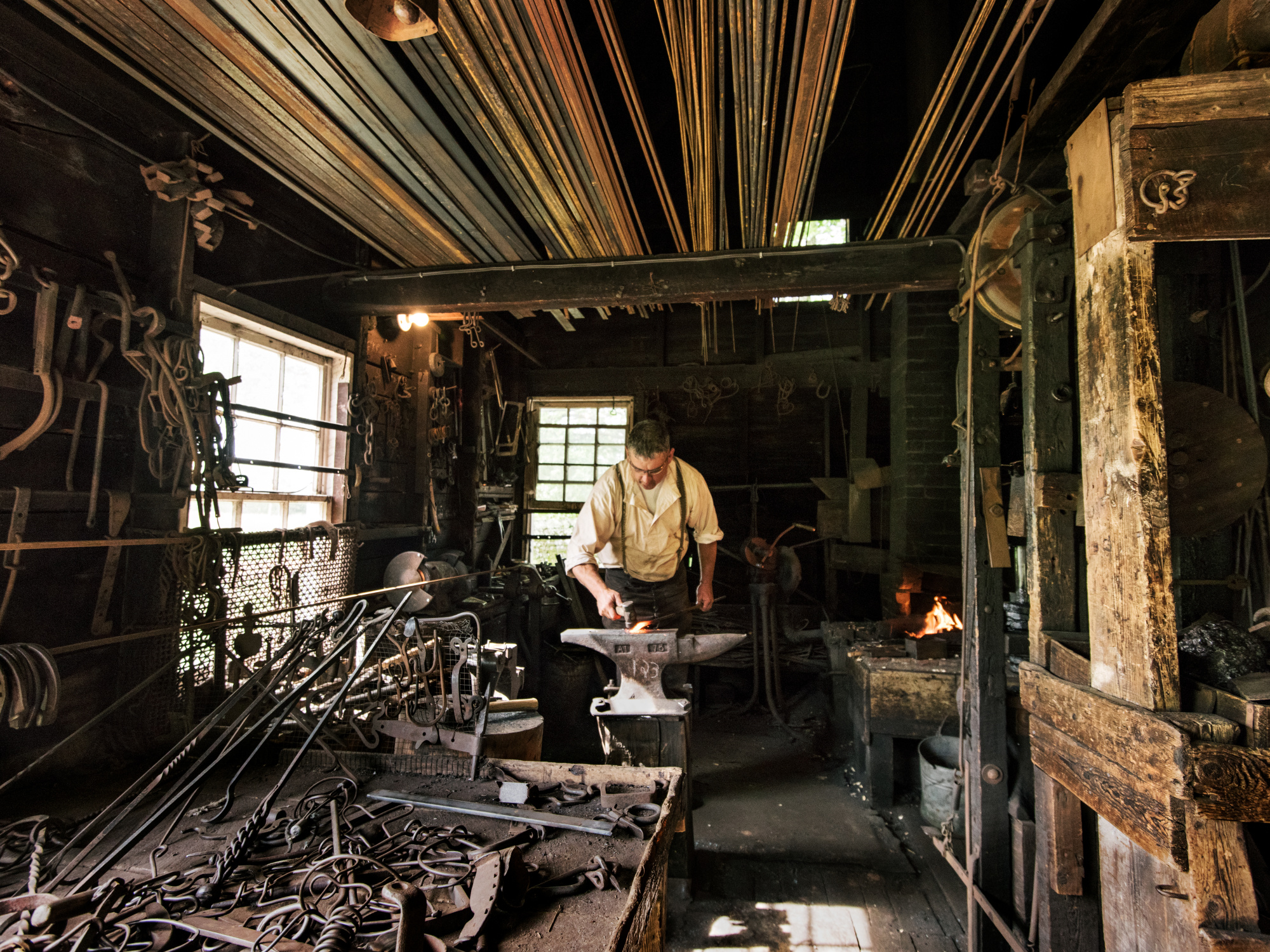 Costumed interpreter, a male working in the Blacksmith at Ross Farm.